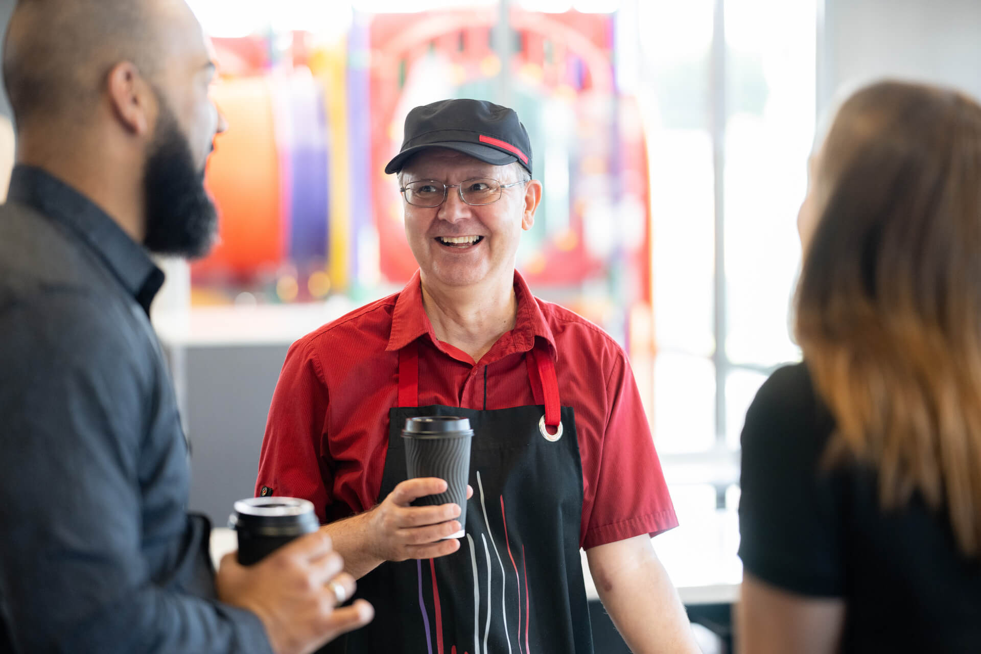 DES participant Darren smiles as he talks to people at work