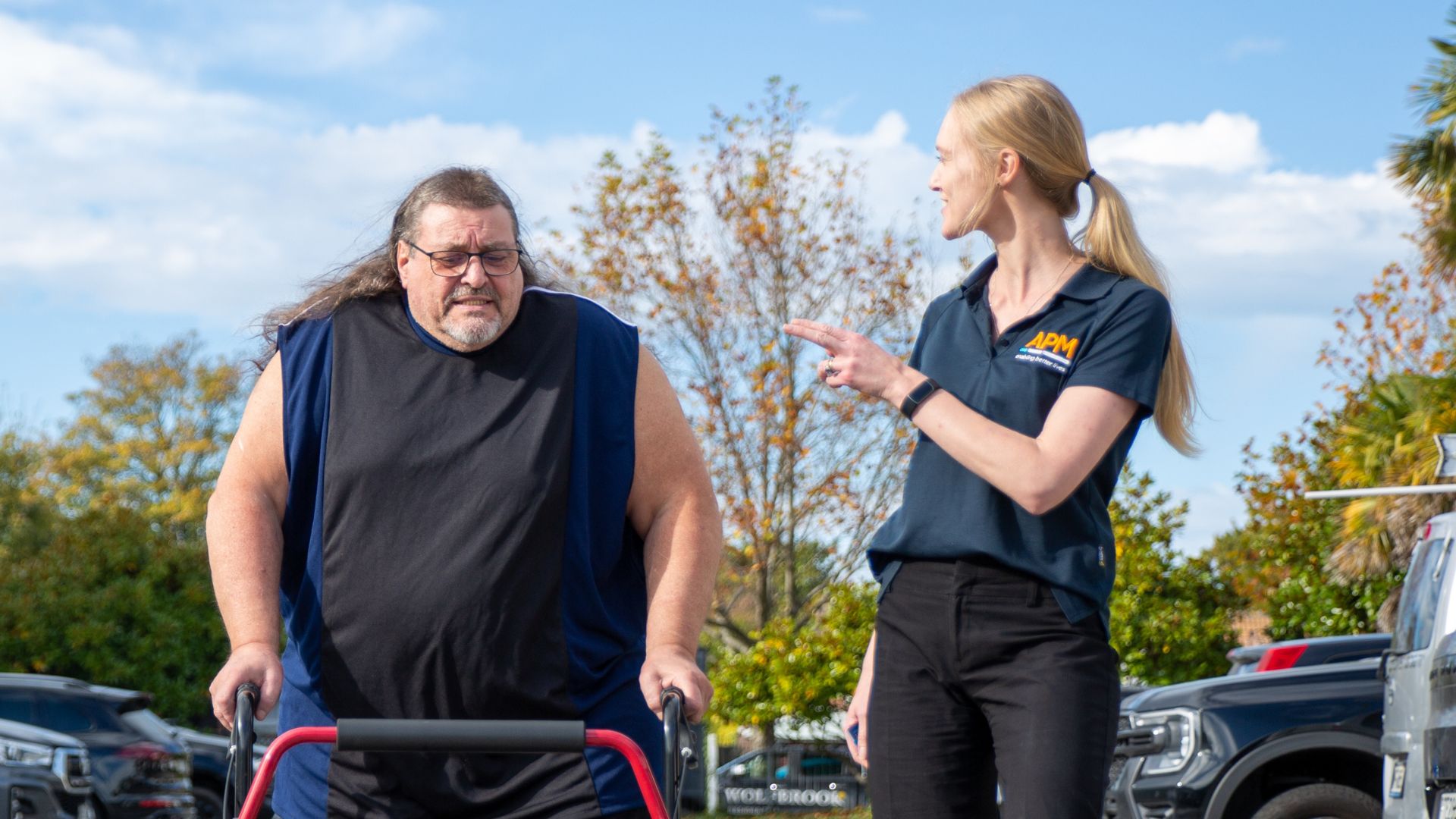 Man moves with walking frame talking to his therapist