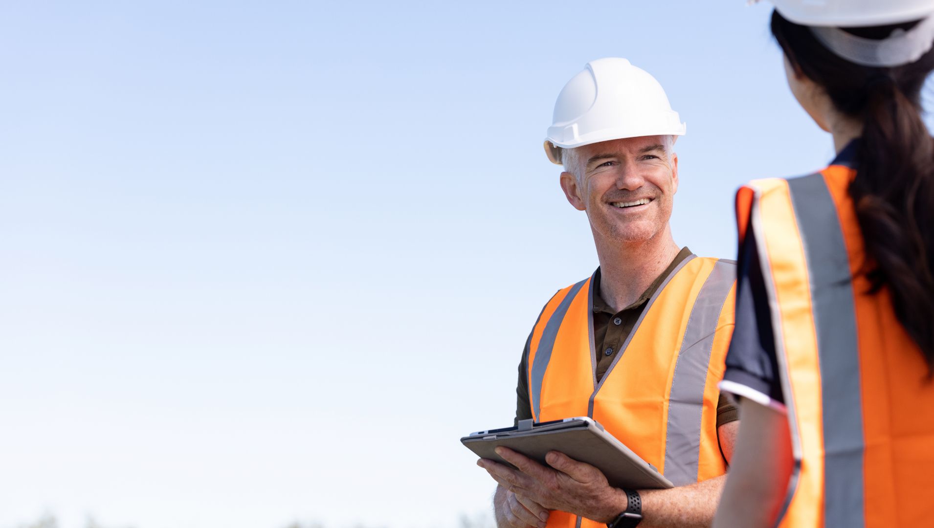 Employer smiles at apprentice in a field of solar panels