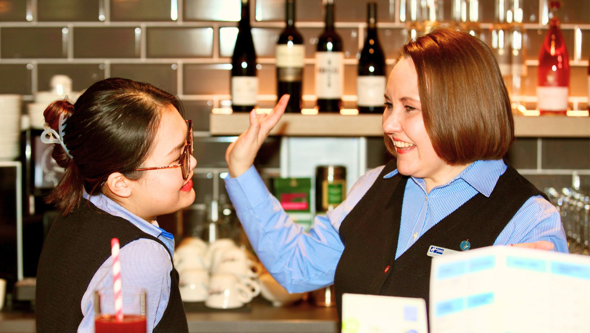 Olena and a colleague talk together by a hotel bar