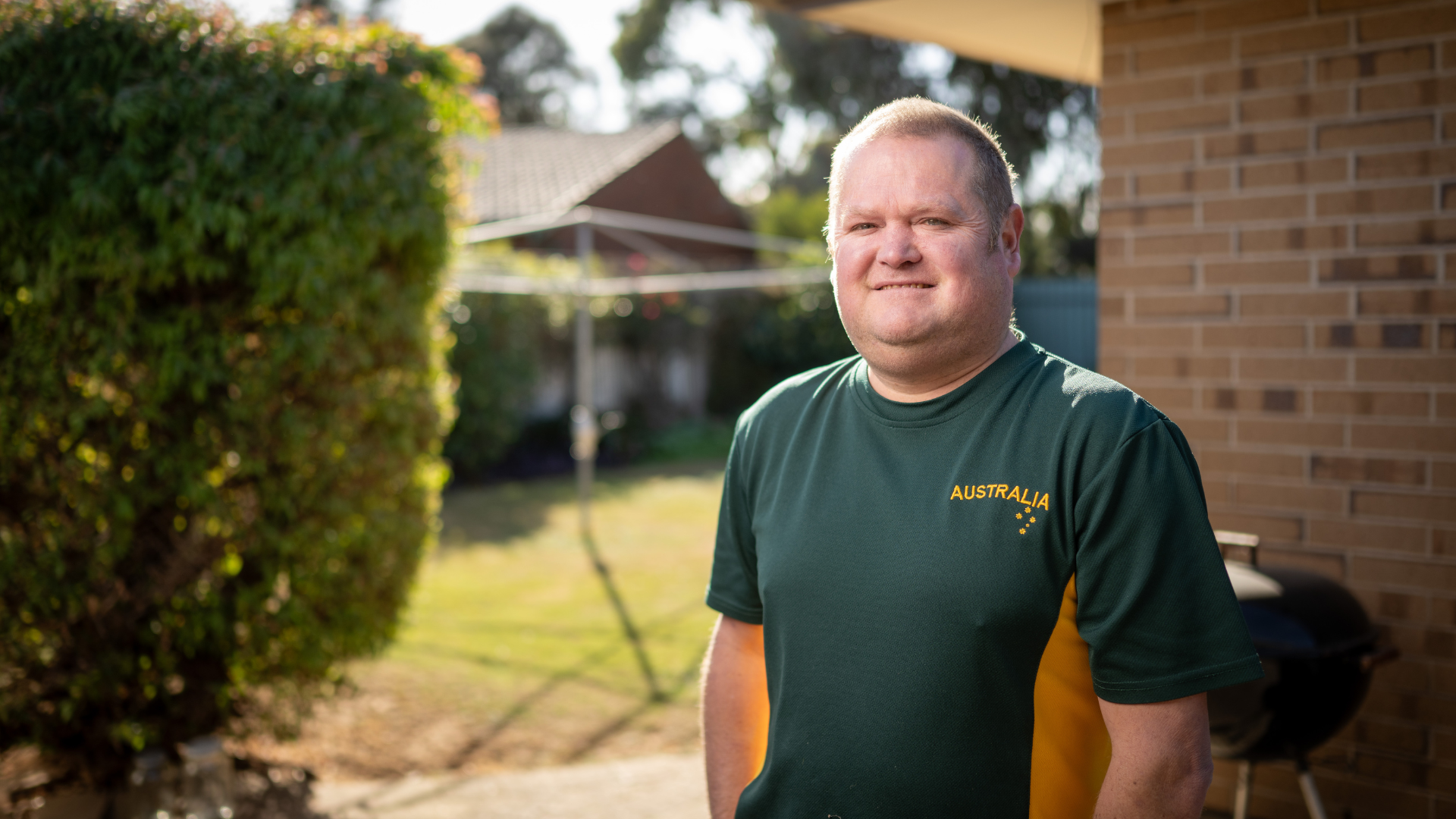 DES participant Eric in an Australia sports top outside his home