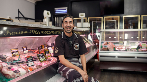 Dan smiles in a butcher shop