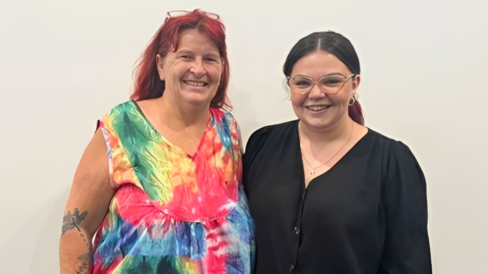 A DES participant in a colourful dress smiles next to her APm consultant