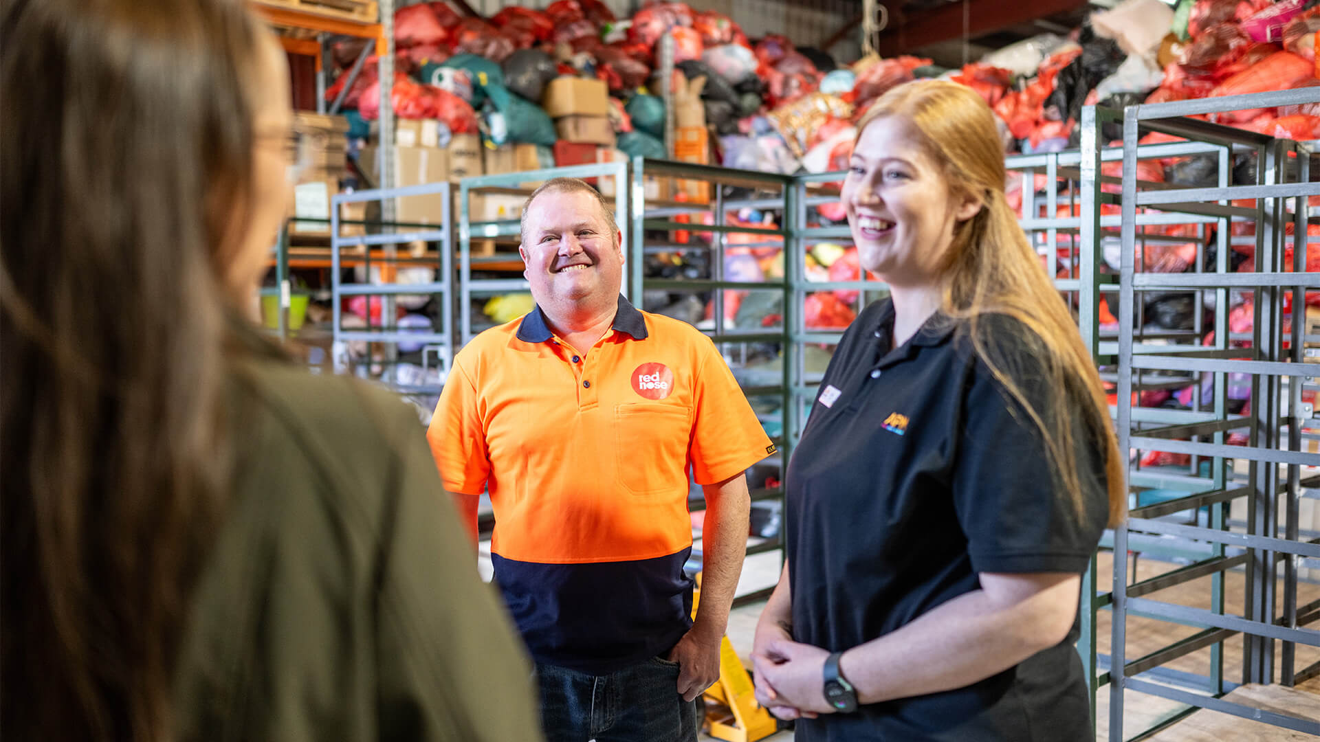 A woman and man smiling in a warehouse discussing DES