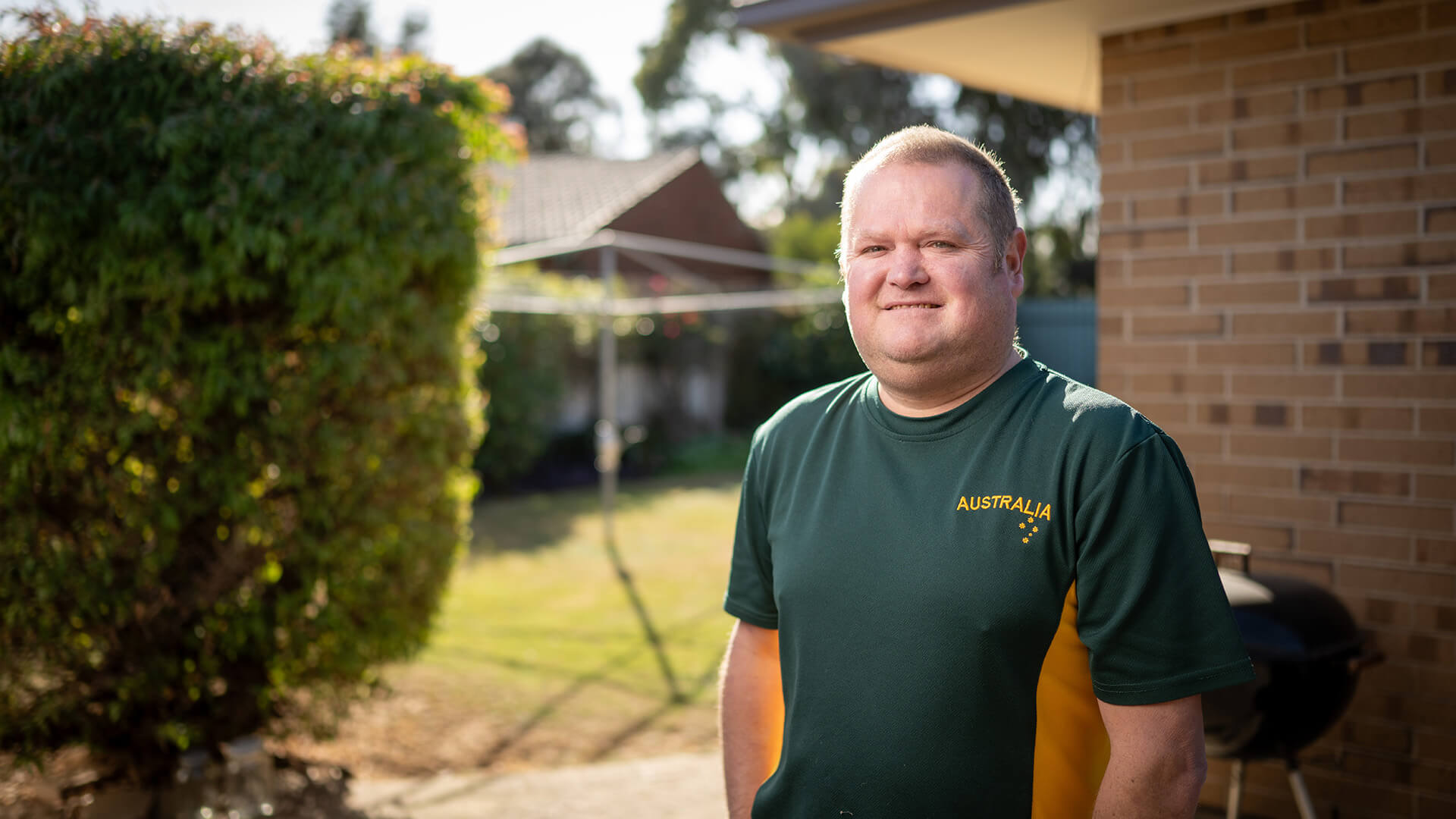 Eric smiles at home in an Australia shirt