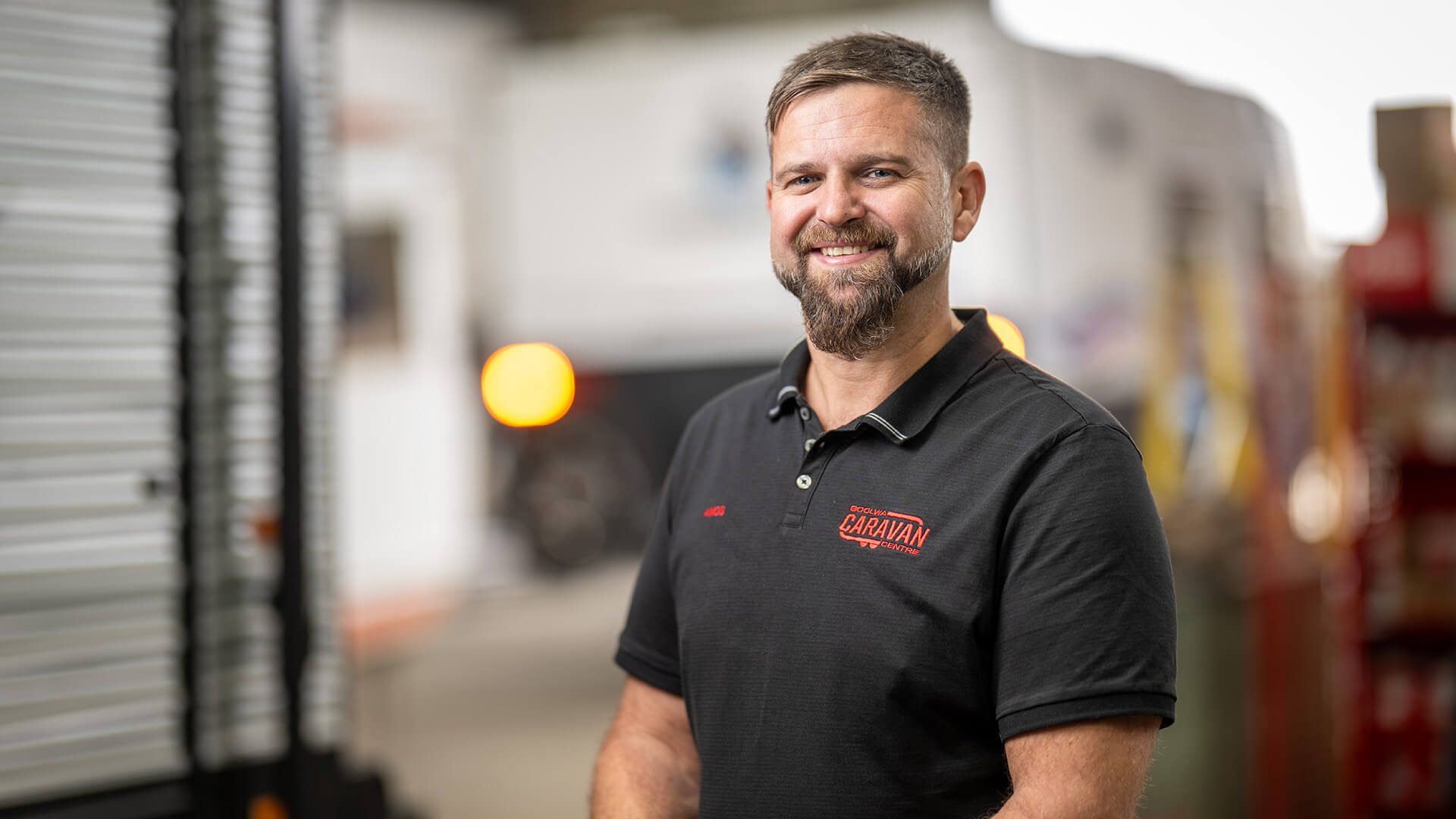 DES employer happy in a black top outside his business supported by APM