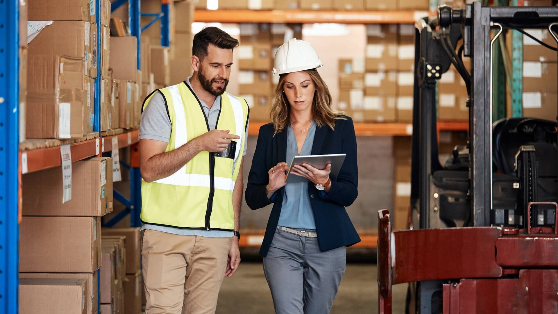 Two colleagues having a discussion while walking through a warehouse