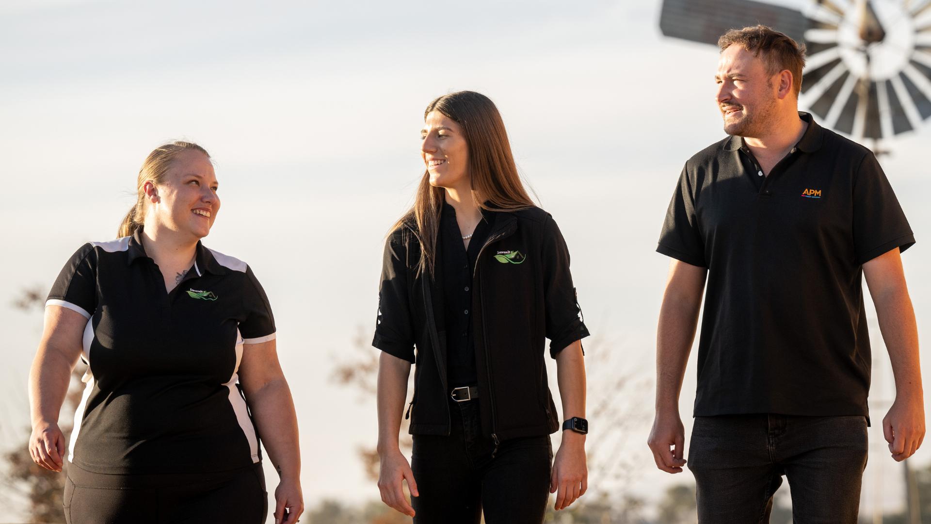 Three people walking and smiling together